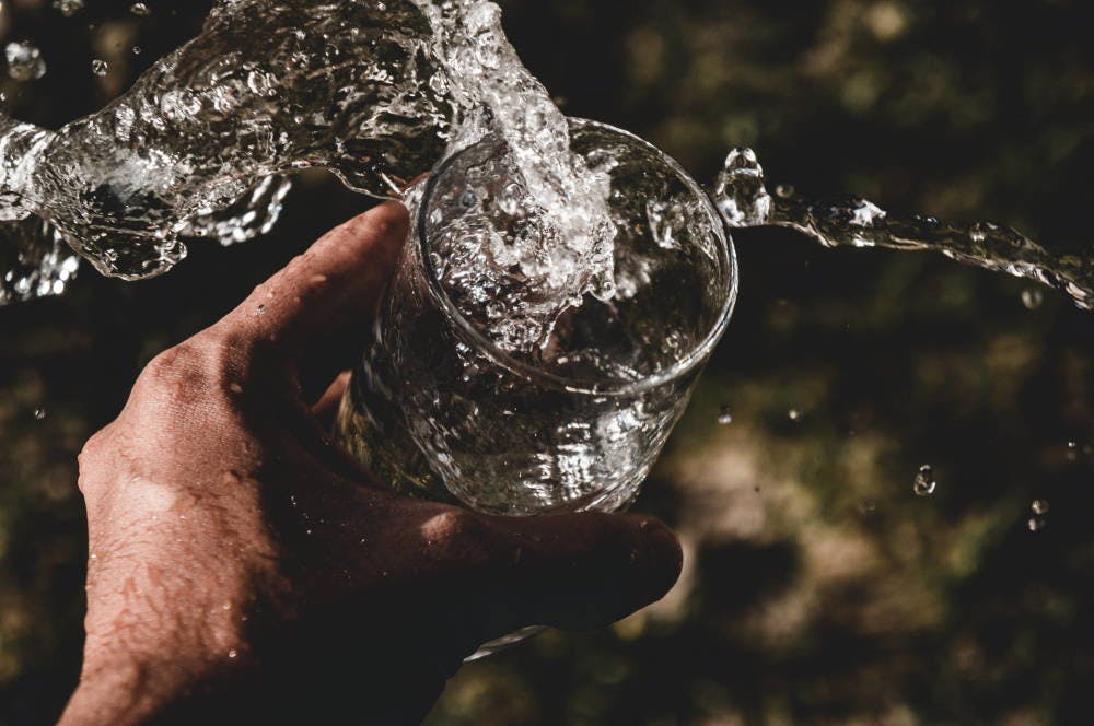 Glass of water with the water splashing out