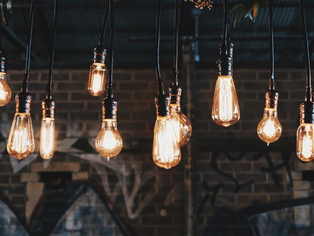 Lightbulbs hanging from the ceiling against an urban background